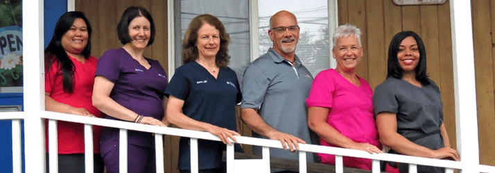 Dr. Jeff Toschwith the team standing together on the porch, representing friendly, professional staff unity.