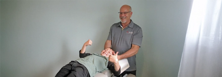 Child giving a thumbs‑up while receiving a relaxed chiropractic adjustment on the treatment table from Dr. Jeff Tosch.